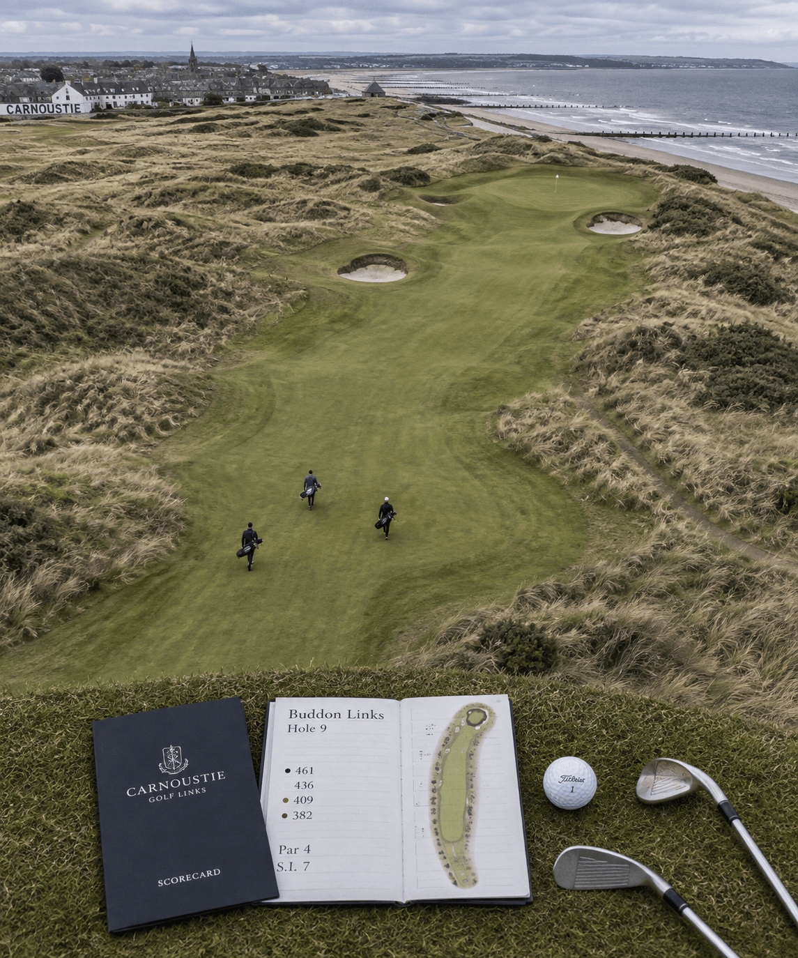 Bird’s-eye view of Carnoustie links with golfers on the fairway, dunes, bunkers, a scorecard, and carnoustie golf clubs nearby.